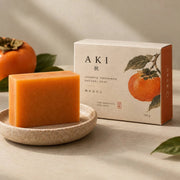 AKI persimmon soap box and bar beside a ripe persimmon