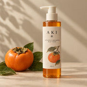 The Wash, 100 ml pump bottle, beside a persimmon